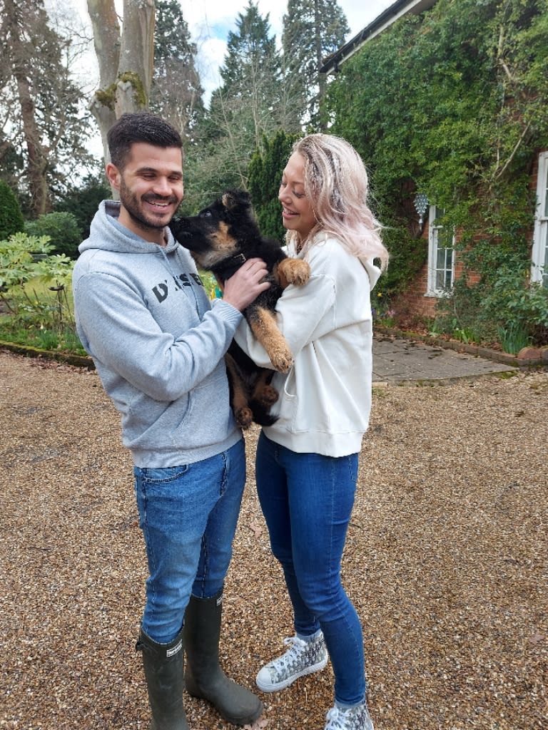 Happy couple holding a small puppy