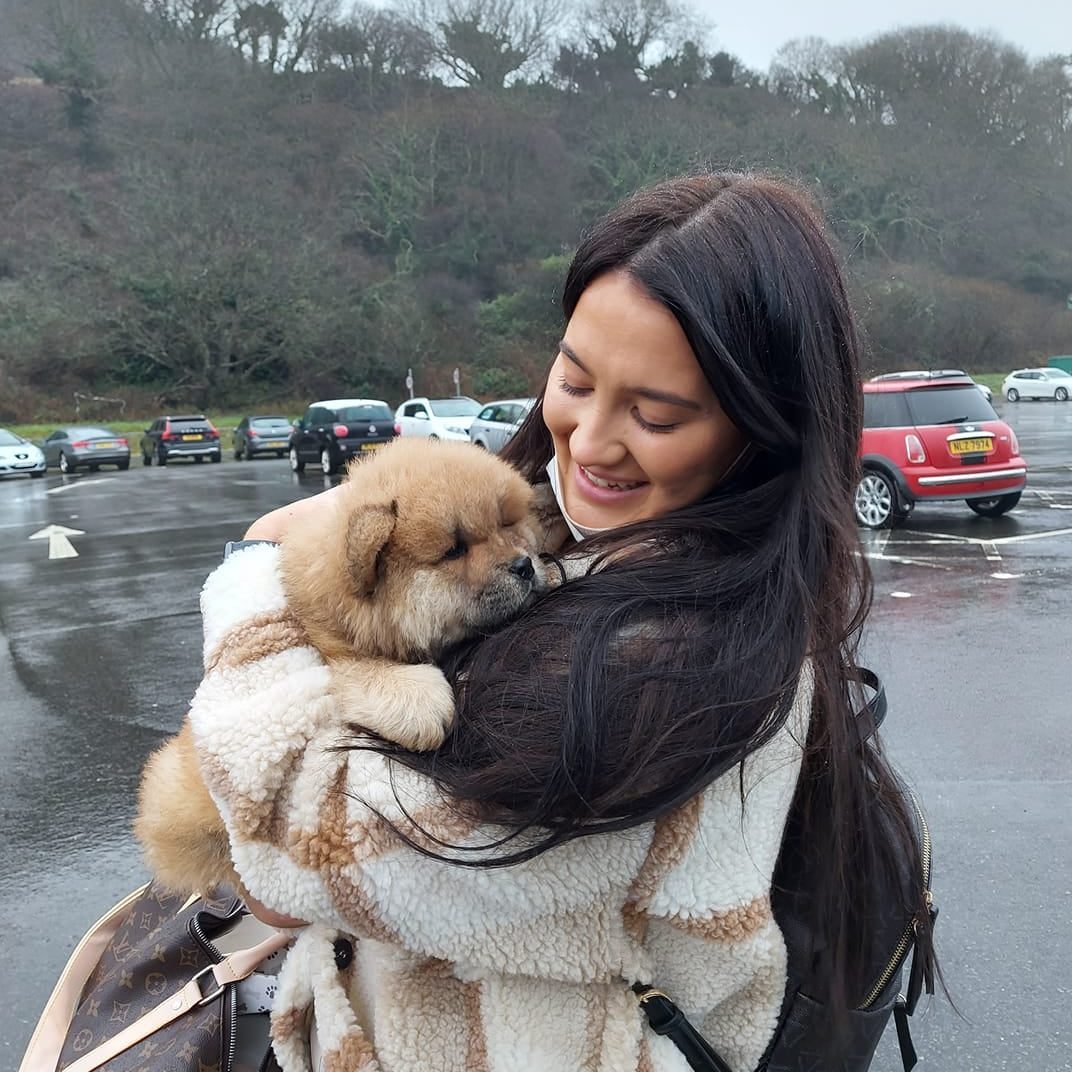 Happy girl holding small puppy